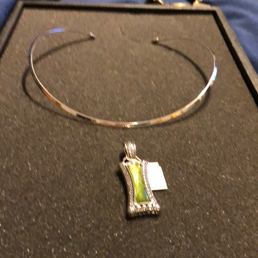 Silver necklace with a green charm.